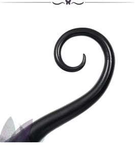 Detail of black spiral horn headpiece with purple and green tulle mesh decoration