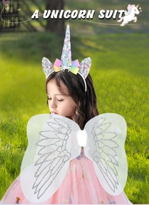 Close-up of kids unicorn headband with rainbow bow and white glitter wings in a park