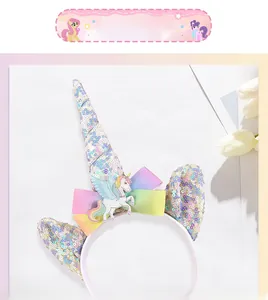 Detail of sequined unicorn headband with rainbow bow and silver horn for kids party