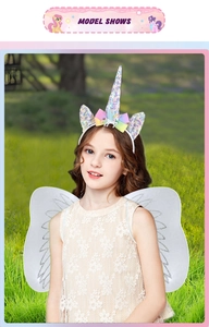 Girl wearing a unicorn headband with rainbow bow and white glitter fairy wings for costumes