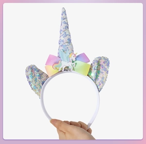 Close-up of unicorn headband featuring rainbow bow, sequin horn and cartoon badge
