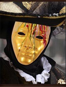 Artistic gold mask with colorful paint drips, black feather hat and baroque ruff detail