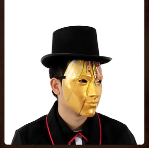Detail of gold mirror mask with paint drips paired with a black top hat for costume parties