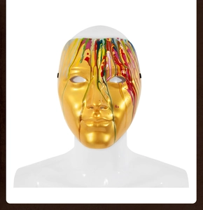 Detail of golden artistic masquerade mask featuring colorful paint drip design and eye cutouts