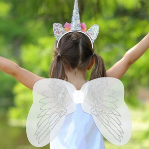 Girl wearing a unicorn headband and white angel wings set for party dress up play