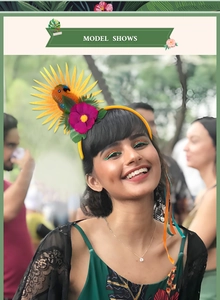 Model trägt ein Tropen-Haarband mit orangem Papagei und Hibiskusblüten für Strandpartys