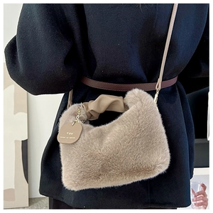 Détails de la texture pelucheuse du sac à bandoulière marron clair avec anse plissée