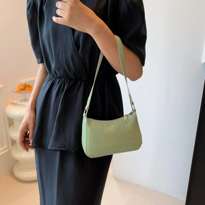 Détail d'un sac baguette vert clair à motif crocodile avec fermeture éclair métallique