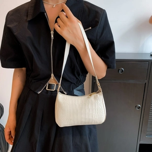 Gros plan du sac bandoulière blanc cassé effet crocodile avec fermeture éclair dorée