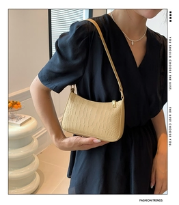 Détail du sac baguette beige en similicuir avec motif crocodile et fermeture éclair dorée