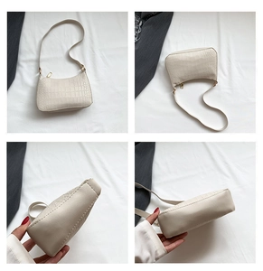 Détails d'un sac à bandoulière blanc à motif crocodile avec des finitions dorées