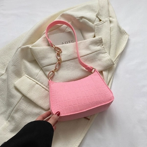 Détail du sac à bandoulière en similicuir rose avec texture croco et chaîne métal