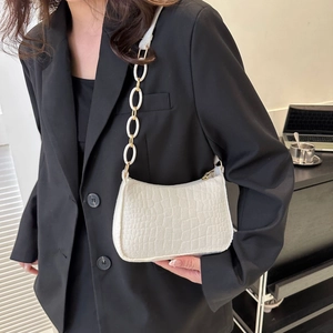 Sac à bandoulière blanc motif crocodile avec grosse chaîne sur blazer noir