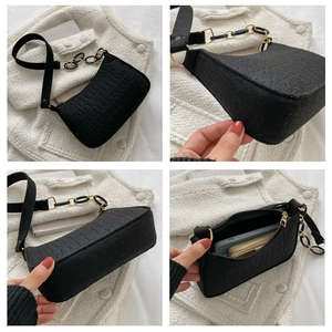 Vue détaillée d'un sac sous les bras noir à motif crocodile avec chaîne dorée décorative