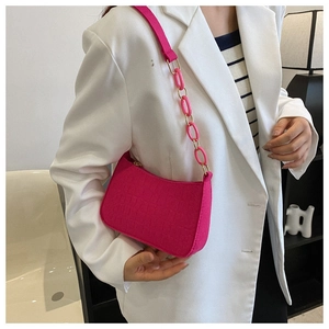 Détail du sac à bandoulière rose fuchsia avec motif crocodile et chaîne en plastique