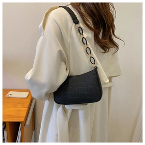 Détail du sac à bandoulière noir gaufré crocodile avec chaîne dorée sur mannequin
