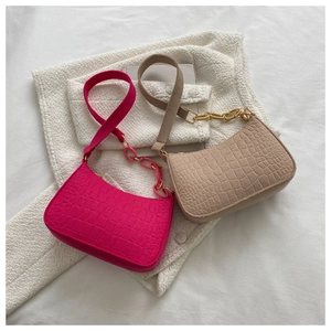 Détail de sacs baguette rose et beige avec motif crocodile et chaîne dorée