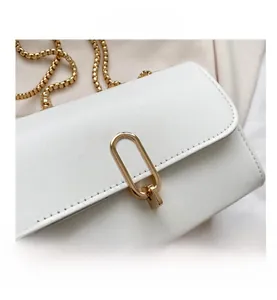 Detail view of a white PU leather square bag with gold metal clasp and chain strap