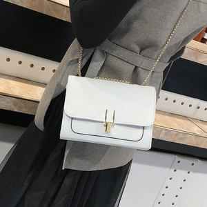 Elegant white quilted crossbody bag with gold chain strap and metallic lock closure