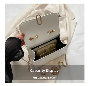 Internal capacity of white faux leather crossbody bag showing space for phone and wallet