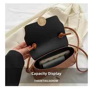 Capacity display of small brown faux leather crossbody bag showing internal space