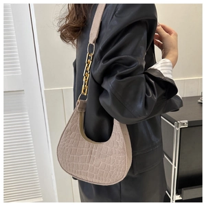 Close-up of beige crocodile pattern hobo bag with metal chain and leather strap