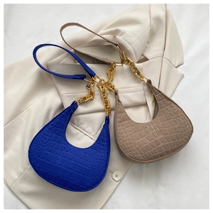 Detail of hobo underarm bags in blue and khaki with croc texture and gold chain straps