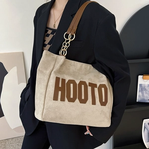 Beige wool tote bag with brown HOOTO print and gold chain strap shown on model