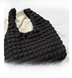 Close-up of the black popcorn texture fabric and pleated detail of the tote bag