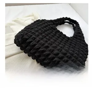 Detailed macro view of the black bubble crepe texture on a modern minimalist tote bag