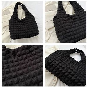 Macro detail of black popcorn texture on large capacity pleated shoulder tote bag