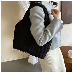 Vue détaillée du tissu à bulles noir sur un sac fourre-tout avec plis doux et rembourrés