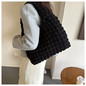 Detail of black bubble textured tote bag showing unique 3D pleated polyester fabric finish