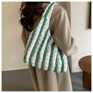Close-up of green and white striped seersucker tote bag showing textured puffy fabric