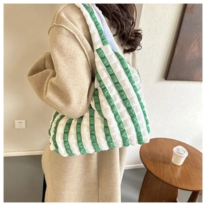 Detail of green and white striped tote bag showing bubble pleated fabric texture