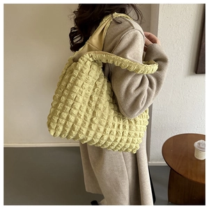 Detail of light yellow popcorn texture tote bag with thick strap for casual commute