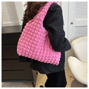 Detail of soft pink bubble textured fabric on a large quilted shoulder tote bag