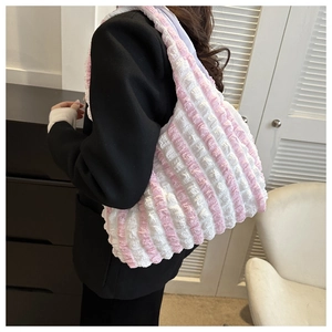 Detail view of pink and white striped bubble fabric texture on a large hobo shoulder bag