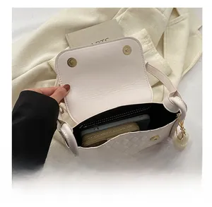 Detail view of beige quilted handbag interior showing spacious capacity for phone and wallet