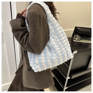Detail of blue and white striped tote bag featuring a unique popcorn bubble texture
