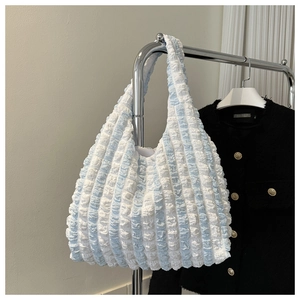 Detail of blue and white striped tote bag showing unique bubble textured pleated fabric