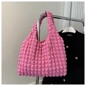 Detailed view of pink cloud puff tote bag with 3D embossed bubble texture on black coat