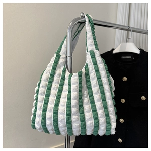 Détail d'un sac cabas à rayures vertes et blanches avec texture de bulles gaufrées