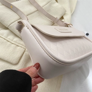 Dettaglio borsa a tracolla trapuntata bianco off-white con finiture dorate e scritte