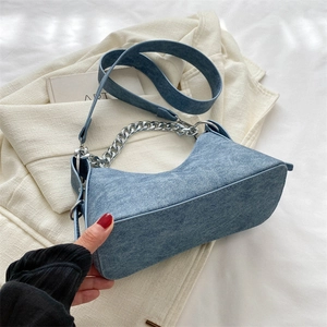 Detail view of the vintage blue denim crescent bag with silver chain and shoulder strap