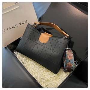 Detail of black geometric bag with ethnic pattern strap in gift packaging