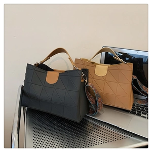 Detail of black and khaki PU leather tote bags with geometric stitching and patterned straps