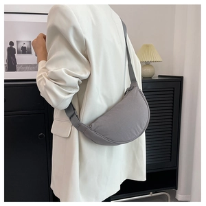 Détail du sac croissant en nylon gris avec bandoulière réglable au style minimaliste