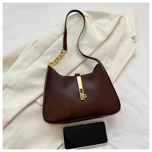 Détail du sac sous le bras marron avec bandoulière dorée et fermoir rétro en métal