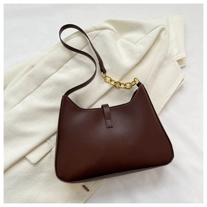 Détail du sac sous le bras vintage en cuir marron avec chaîne dorée et fini lisse